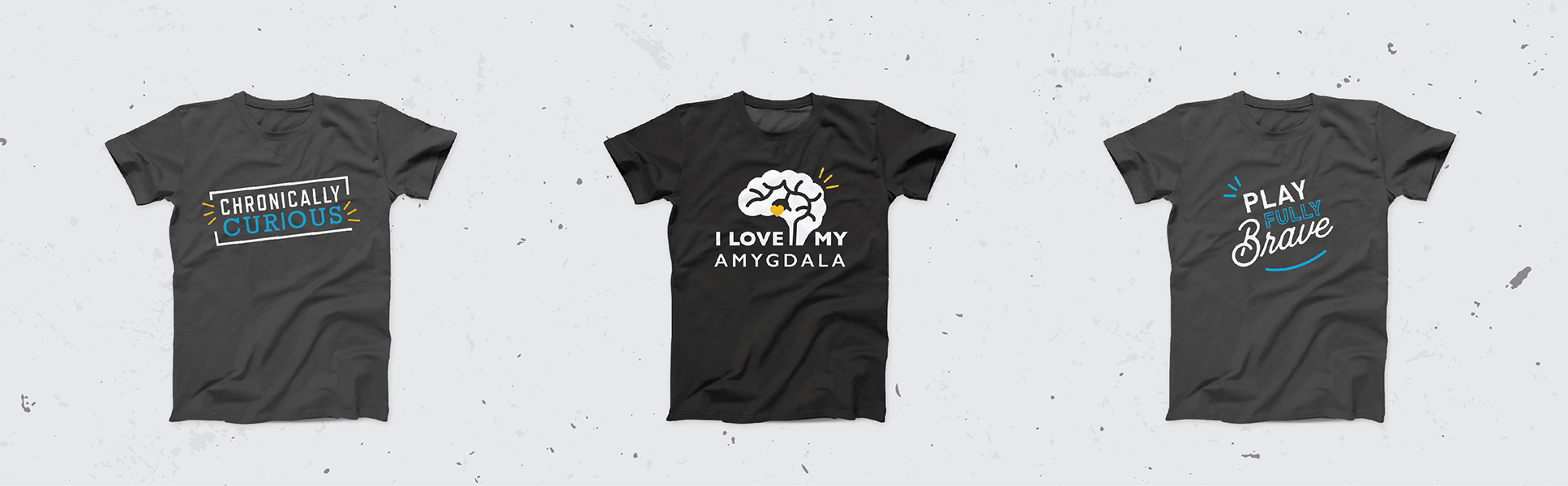 Three branded Sarah Noll Wilson T-shirts reading "Chronically Curious," "I Love My Amygdala" and "Play Fully Brave"