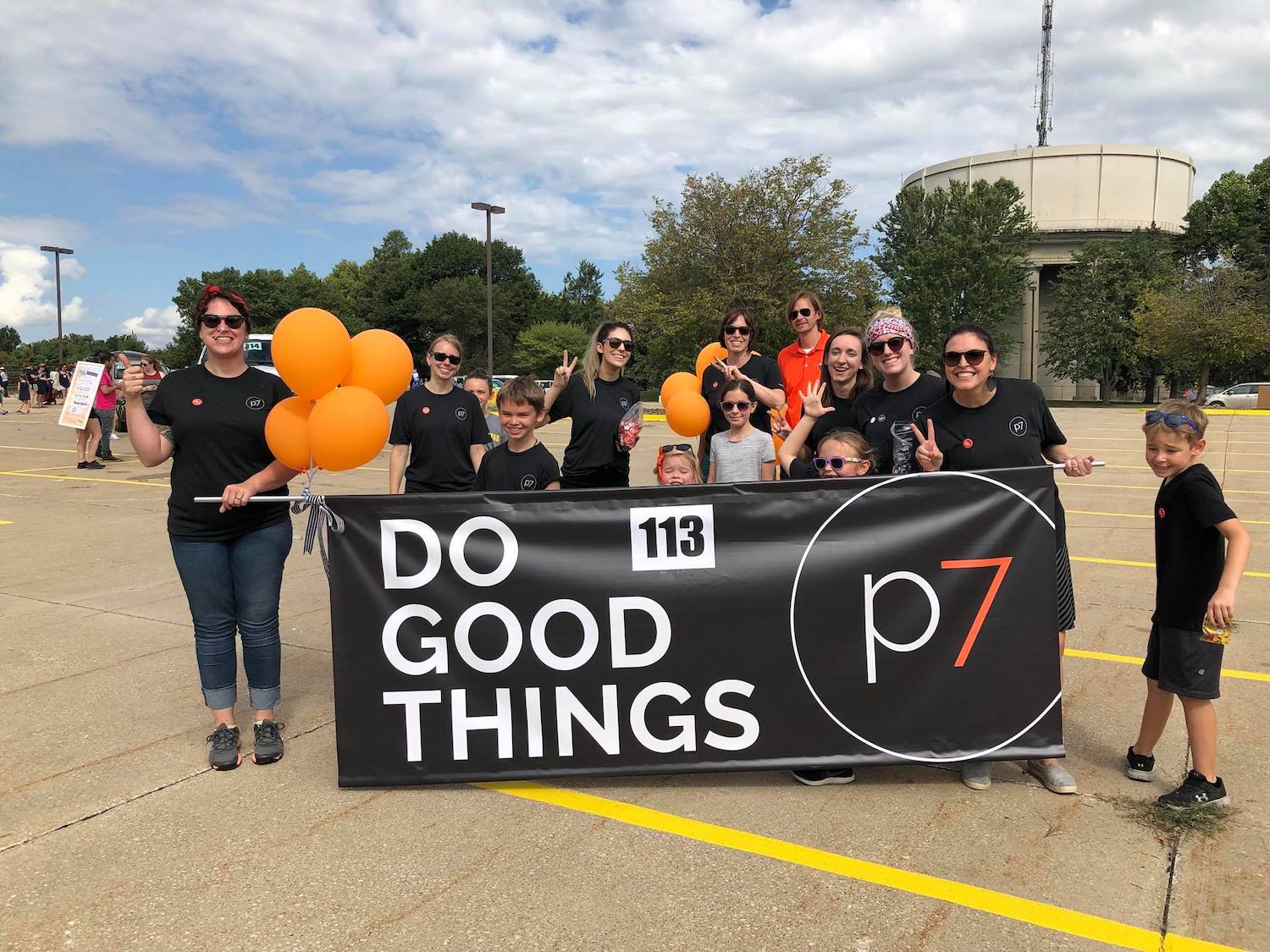 p7 team in a parade holding DO GOOD THINGS banner