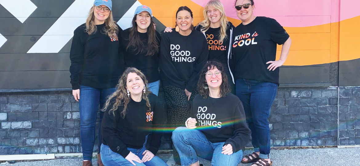 p7 team in project7 design merch in front of Cool to be kind mural in des moines