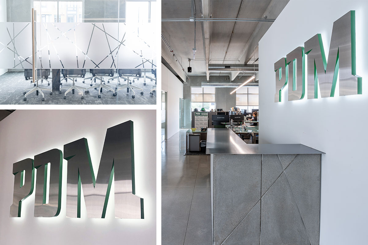 PDM office space with logo wall sign lit up and frosted glass graphics