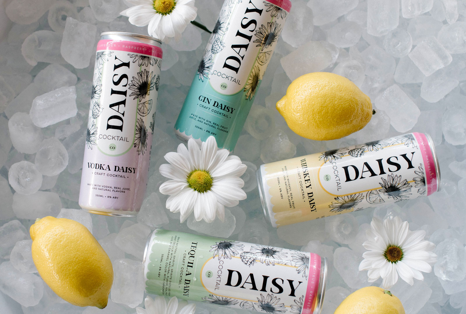 Four tall cans that say Daisy in a bucket of ice with daisy flowers and lemons.