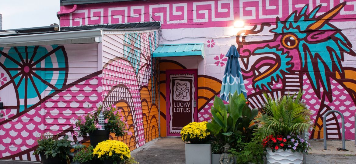 The back side of the Lucky Lotus building has a pink, blue, and orange East Asian Dragon mural.