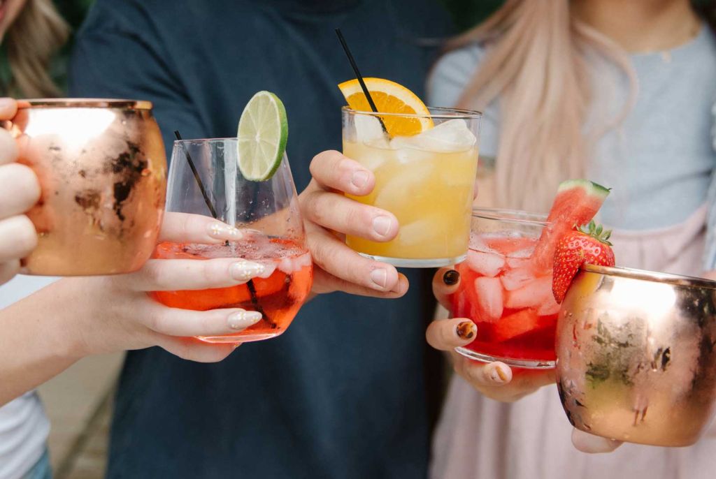 A group of friends with cocktails in hand